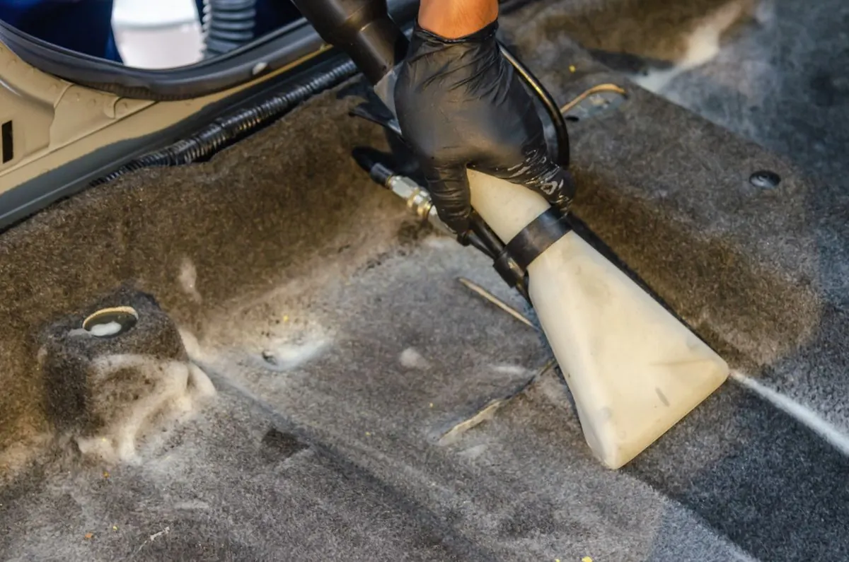 Nettoyage d'une moquette de voiture avec une machine à injection-extraction