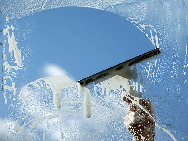Vitre nettoyée à la raclette sous un ciel bleu